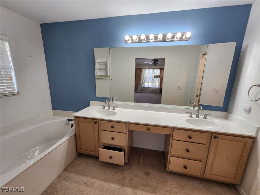 5390 Park Road, Unit 1 Fort Myers, FL 33908 - Photo 9 of 14 a bathroom with a double vanity sink a tub and a mirror