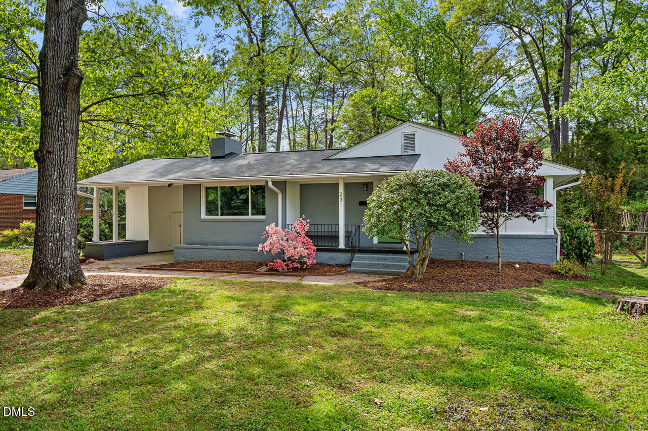 a view of a house with a yard and sitting area