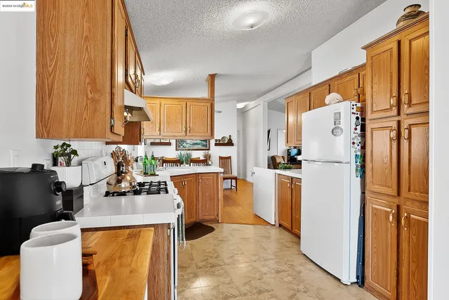 a kitchen with a refrigerator a stove a sink dishwasher and cabinets with wooden floor