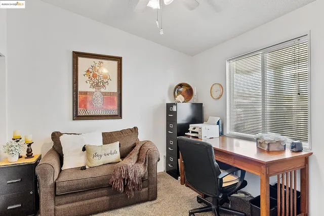 a view of a workspace with furniture and a window