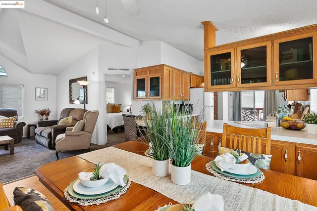 a living room with furniture and a dining table with wooden floor