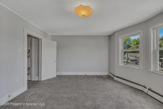 an empty room with windows and tub