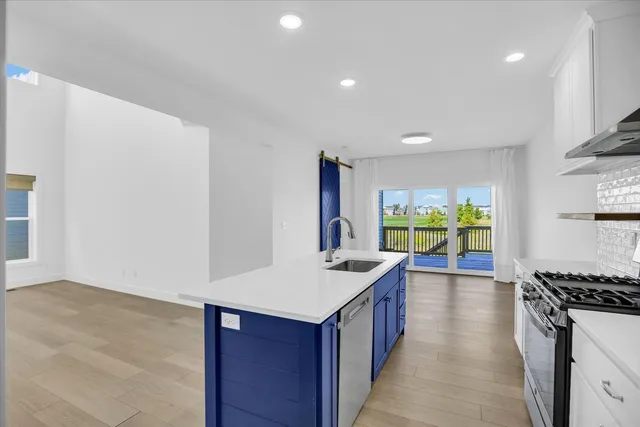 a kitchen with stainless steel appliances granite countertop a stove a sink and a refrigerator