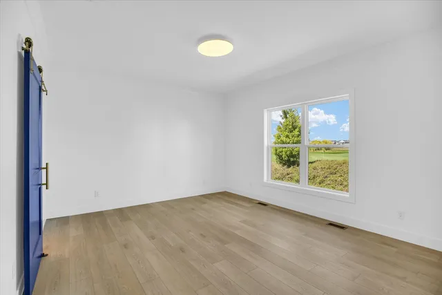 an empty room with window and mirror