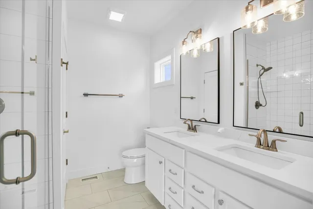 a bathroom with a double vanity sink a toilet and a mirror