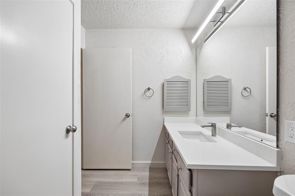 11480 Audelia Road, Unit 136 Dallas, TX 75243 - Photo 16 of 29 Bathroom featuring a vanity with an integrated rectangular sink, light-toned countertop, and a brushed nickel faucet