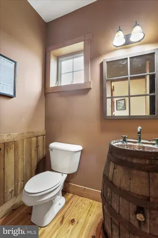 a kitchen with stainless steel appliances granite countertop a refrigerator a sink dishwasher a stove and white cabinets with wooden floor