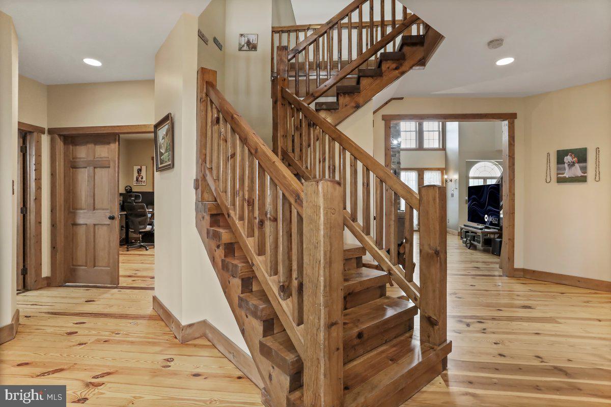 9763 Blue Spring Road Mercersburg, PA 17236 - Photo 14 of 85 a view of staircase with lots of frames on wall and wooden floor