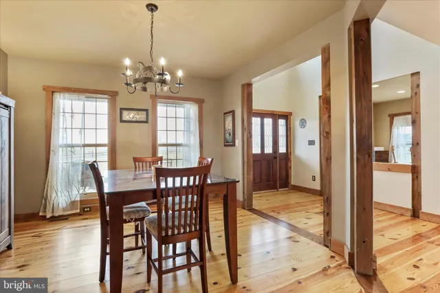 a kitchen with stainless steel appliances granite countertop a stove top oven a sink dishwasher a dining table and chairs with wooden floor