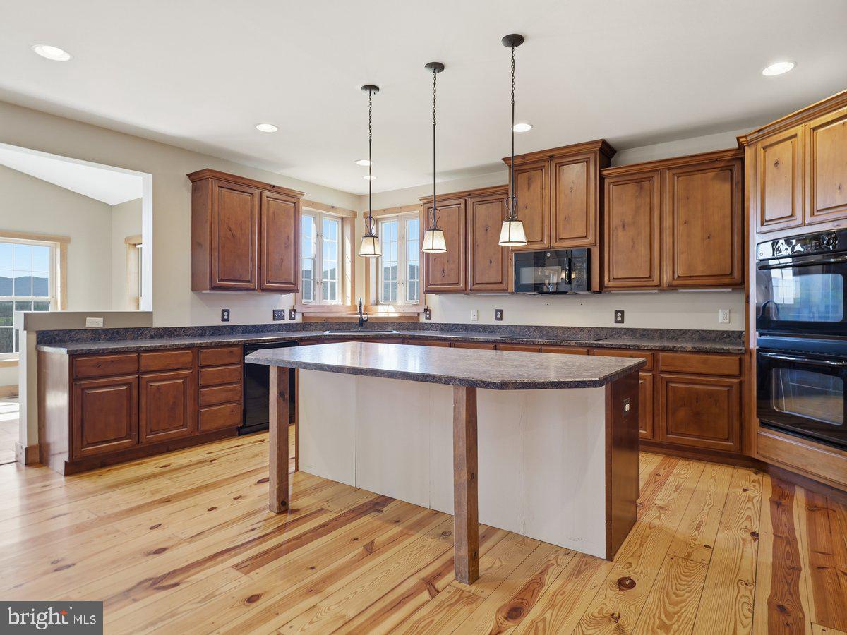 9763 Blue Spring Road Mercersburg, PA 17236 - Photo 24 of 85 a kitchen with stainless steel appliances granite countertop a stove a sink and a wooden floors