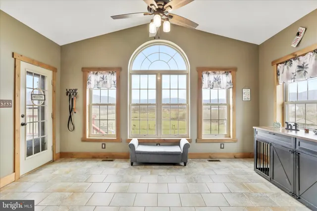 a spacious bathroom with a granite countertop sink a mirror a bathtub and next to a window
