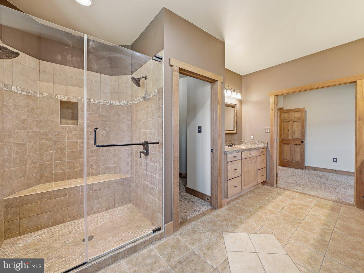 9763 Blue Spring Road Mercersburg, PA 17236 - Photo 36 of 85 a bathroom with a glass shower door and a mirror