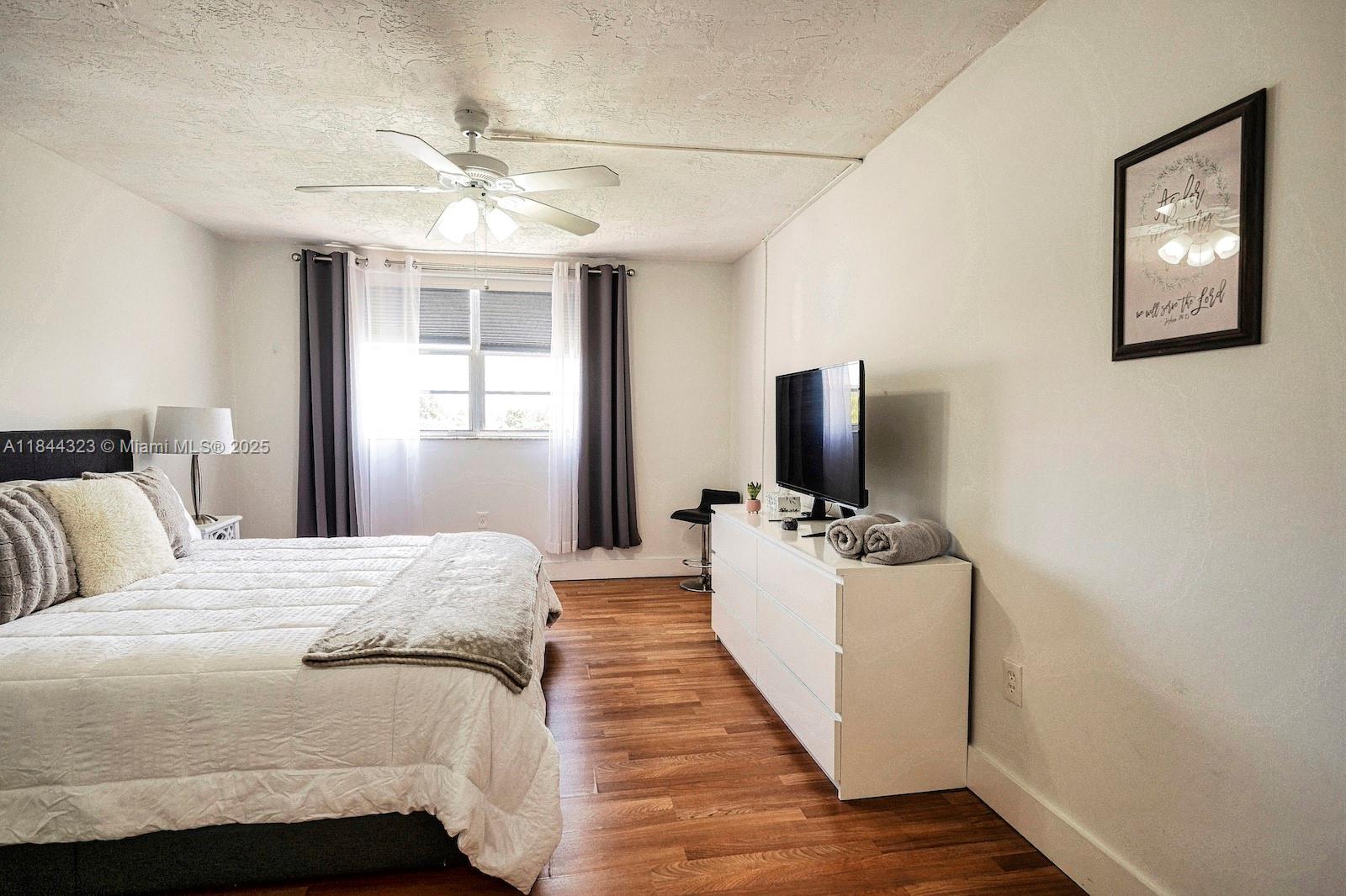 7300 Northwest 17th Street, Unit 415 Plantation, FL 33313 - Photo 12 of 19 a bedroom with a bed and a flat screen tv