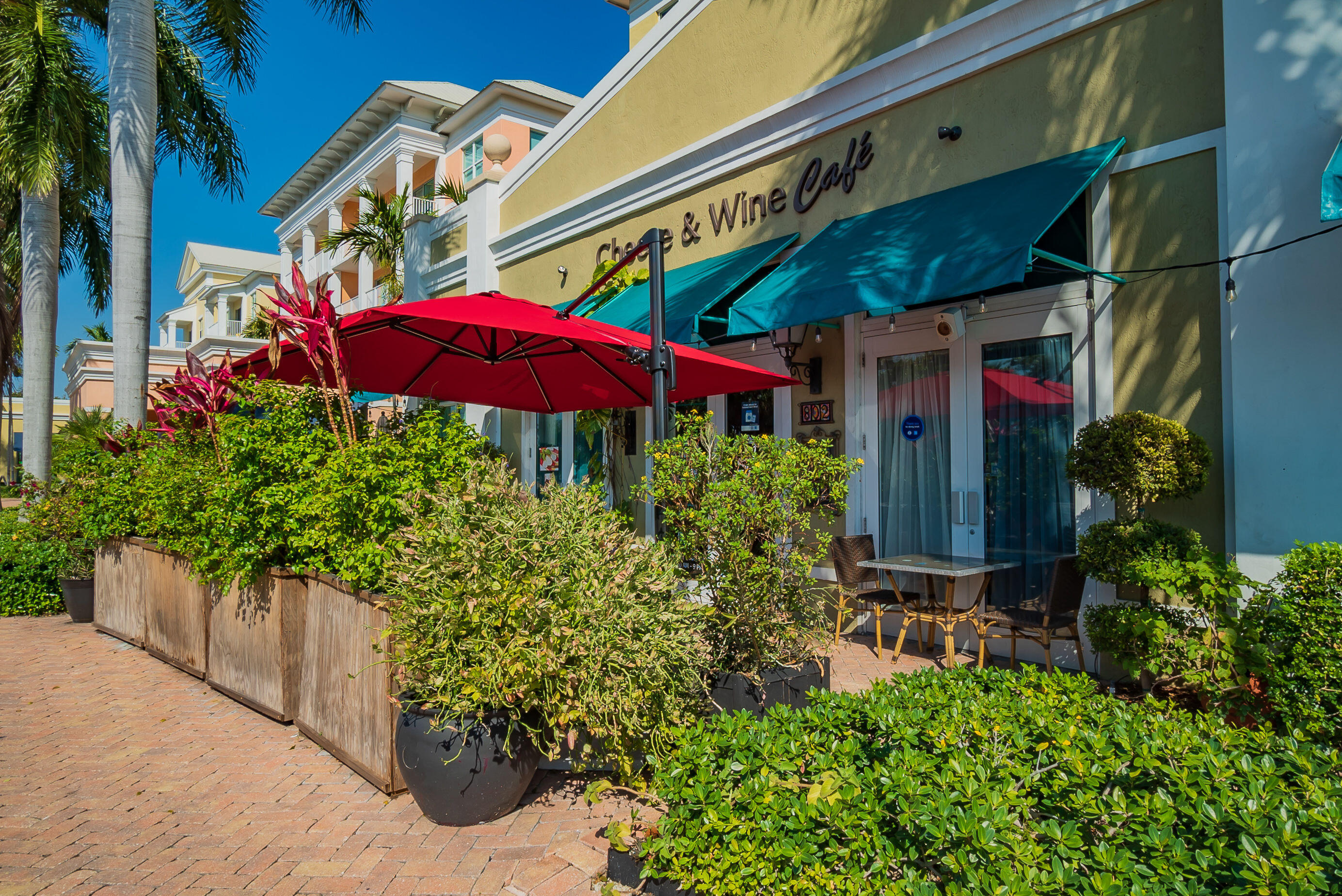 804 East Windward Way, Unit 307 Lantana, FL 33462 - Photo 42 of 44 an outdoor cafe with a table and chairs under an umbrella