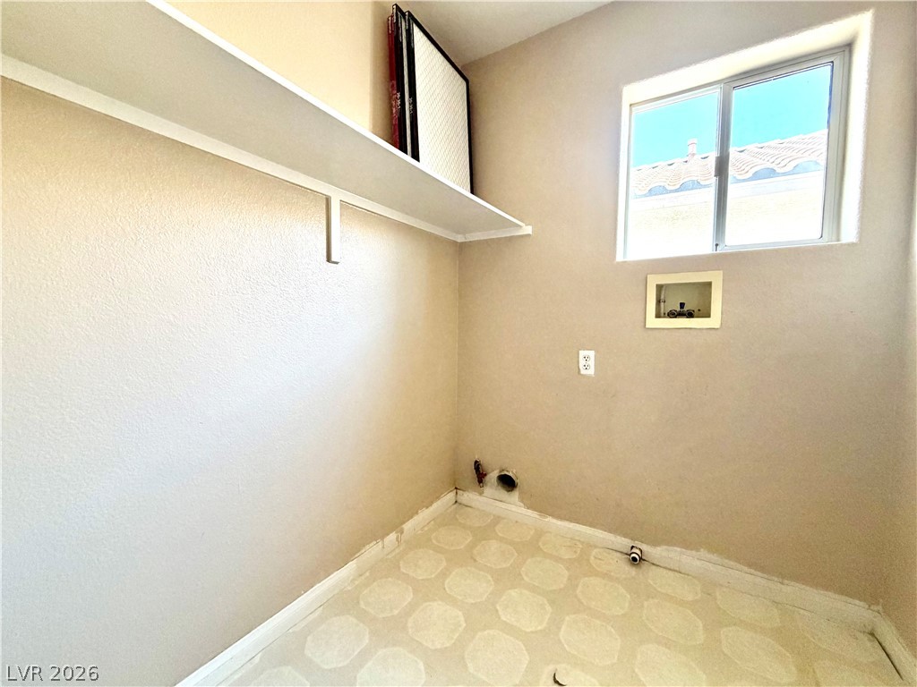 3936 Gold Point Street Las Vegas, NV 89129 - Photo 18 of 23 A well-lit laundry area includes a high shelf and window.