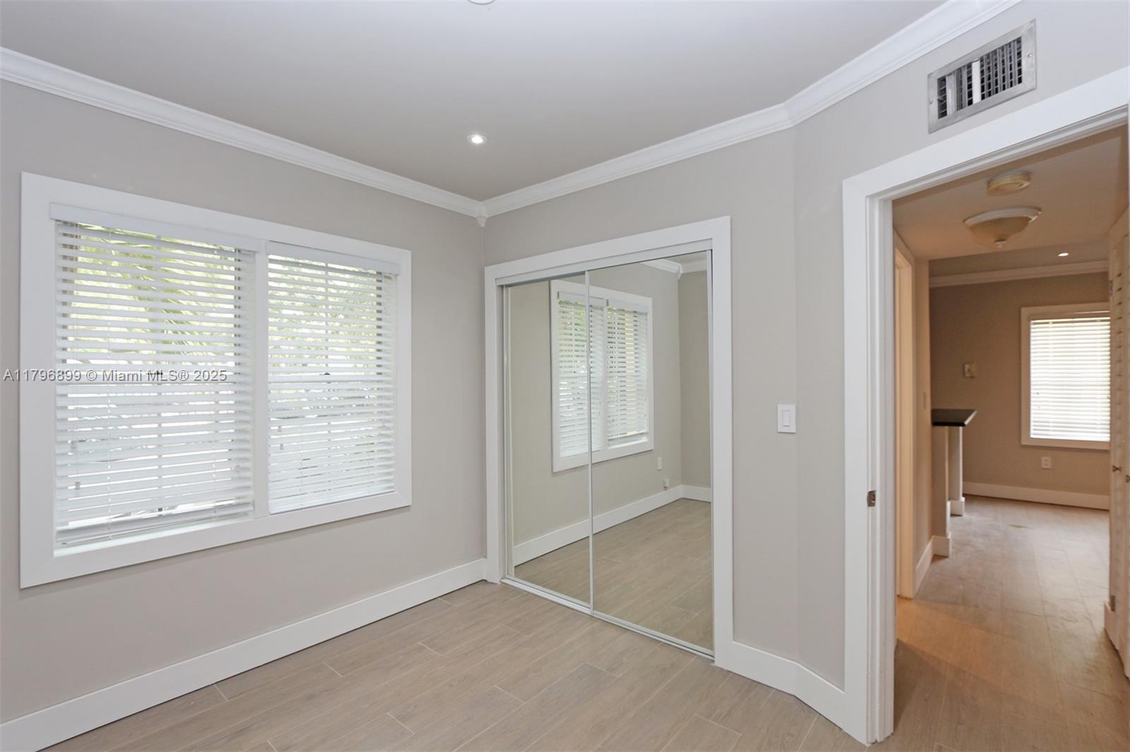 3375 Franklin Avenue, Unit D Miami, FL 33133 - Photo 11 of 33 a view of an empty room with wooden floor and a window