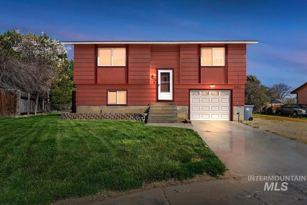 Split foyer home with an attached garage and driveway
