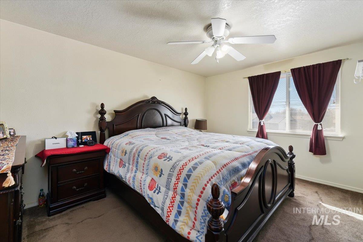 2811 Apollo Place Caldwell, ID 83605 - Photo 13 of 31 Bedroom featuring carpet, ceiling fan, and a textured ceiling