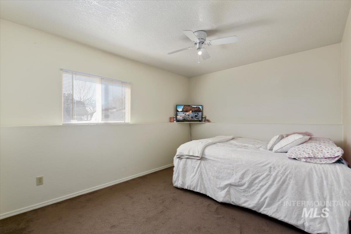2811 Apollo Place Caldwell, ID 83605 - Photo 16 of 31 Bedroom with dark carpet, ceiling fan, and a textured ceiling