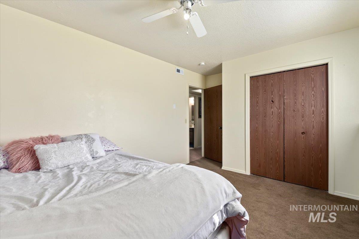 2811 Apollo Place Caldwell, ID 83605 - Photo 17 of 31 Carpeted bedroom featuring a closet, a ceiling fan, and a textured ceiling