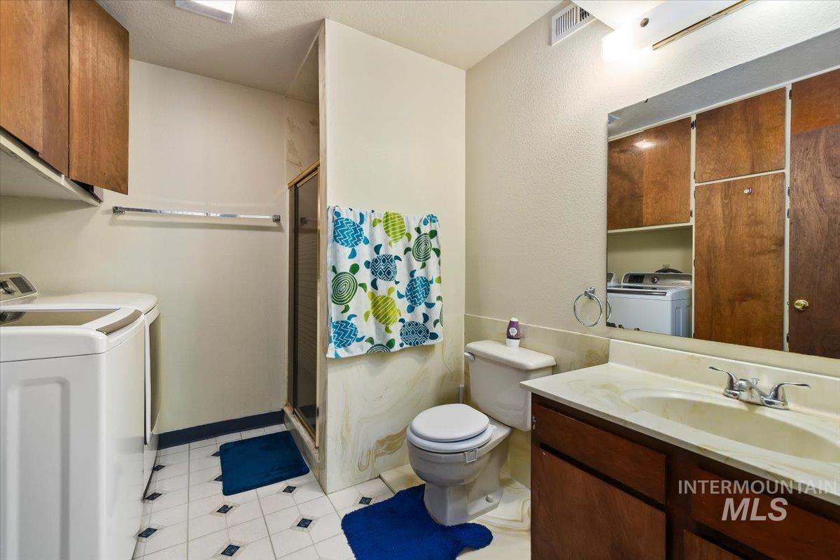 2811 Apollo Place Caldwell, ID 83605 - Photo 18 of 31 Bathroom with vanity, washer and clothes dryer, and a shower stall