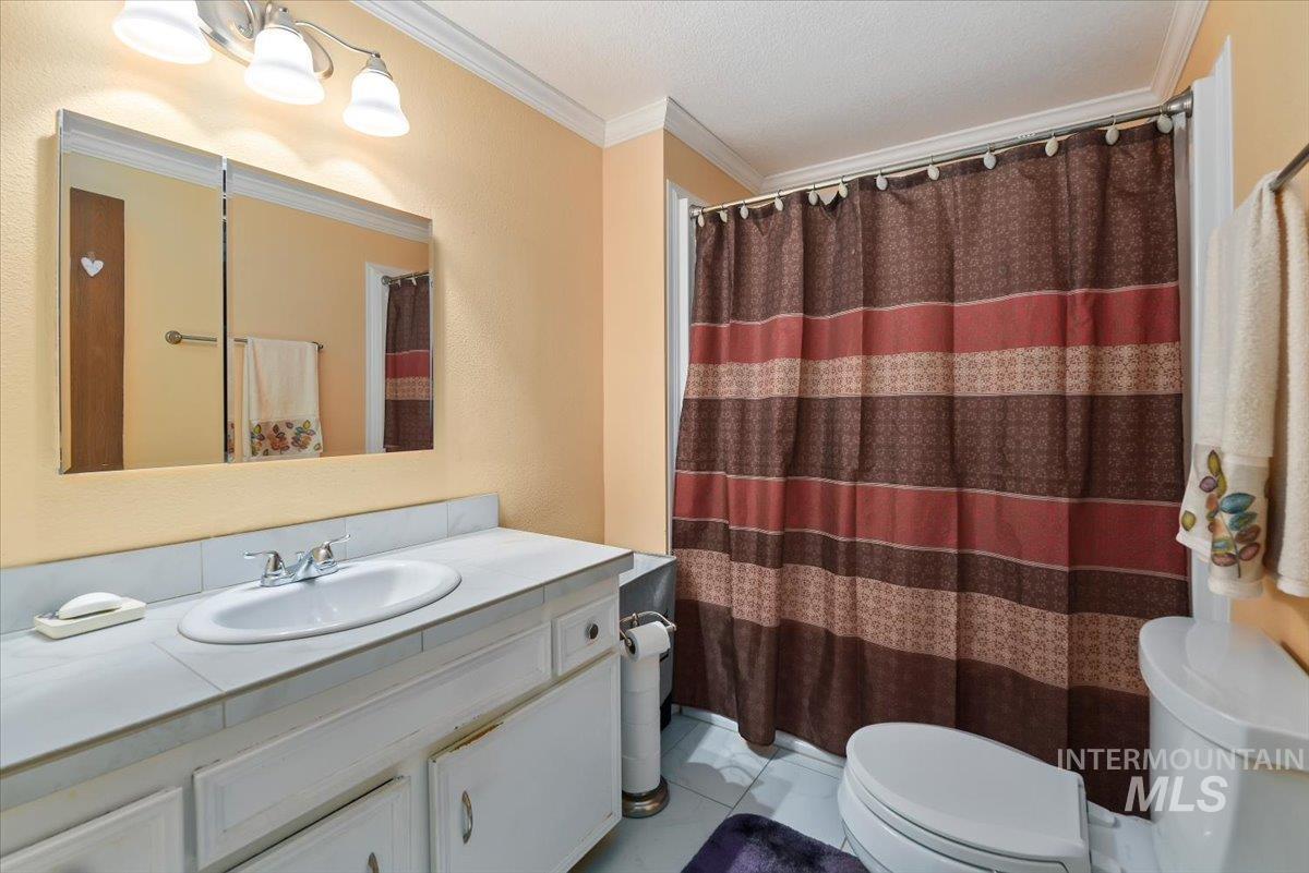 2811 Apollo Place Caldwell, ID 83605 - Photo 20 of 31 Full bath featuring vanity, crown molding, and curtained shower