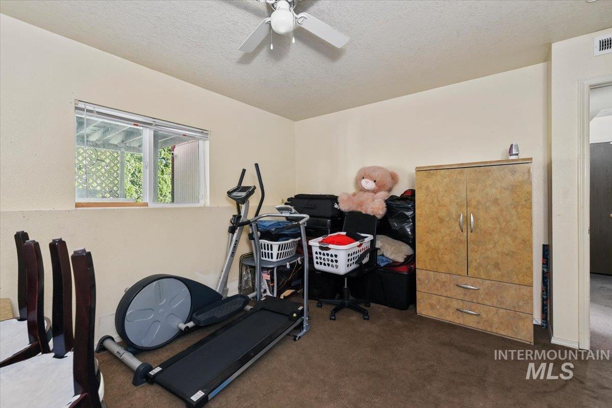 2811 Apollo Place Caldwell, ID 83605 - Photo 22 of 31 Workout area with a textured ceiling, dark colored carpet, and ceiling fan