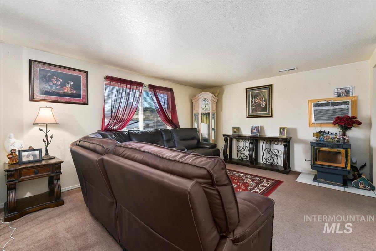 2811 Apollo Place Caldwell, ID 83605 - Photo 6 of 31 Living area featuring carpet flooring and a textured ceiling