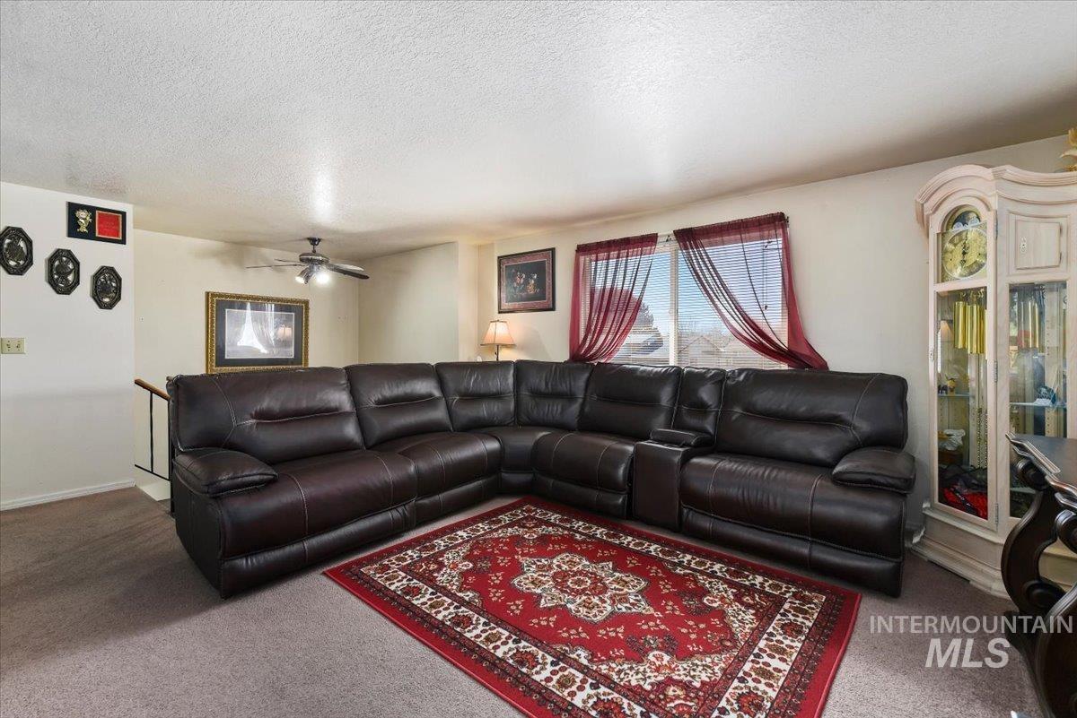 2811 Apollo Place Caldwell, ID 83605 - Photo 7 of 31 Carpeted living area featuring a textured ceiling and a ceiling fan