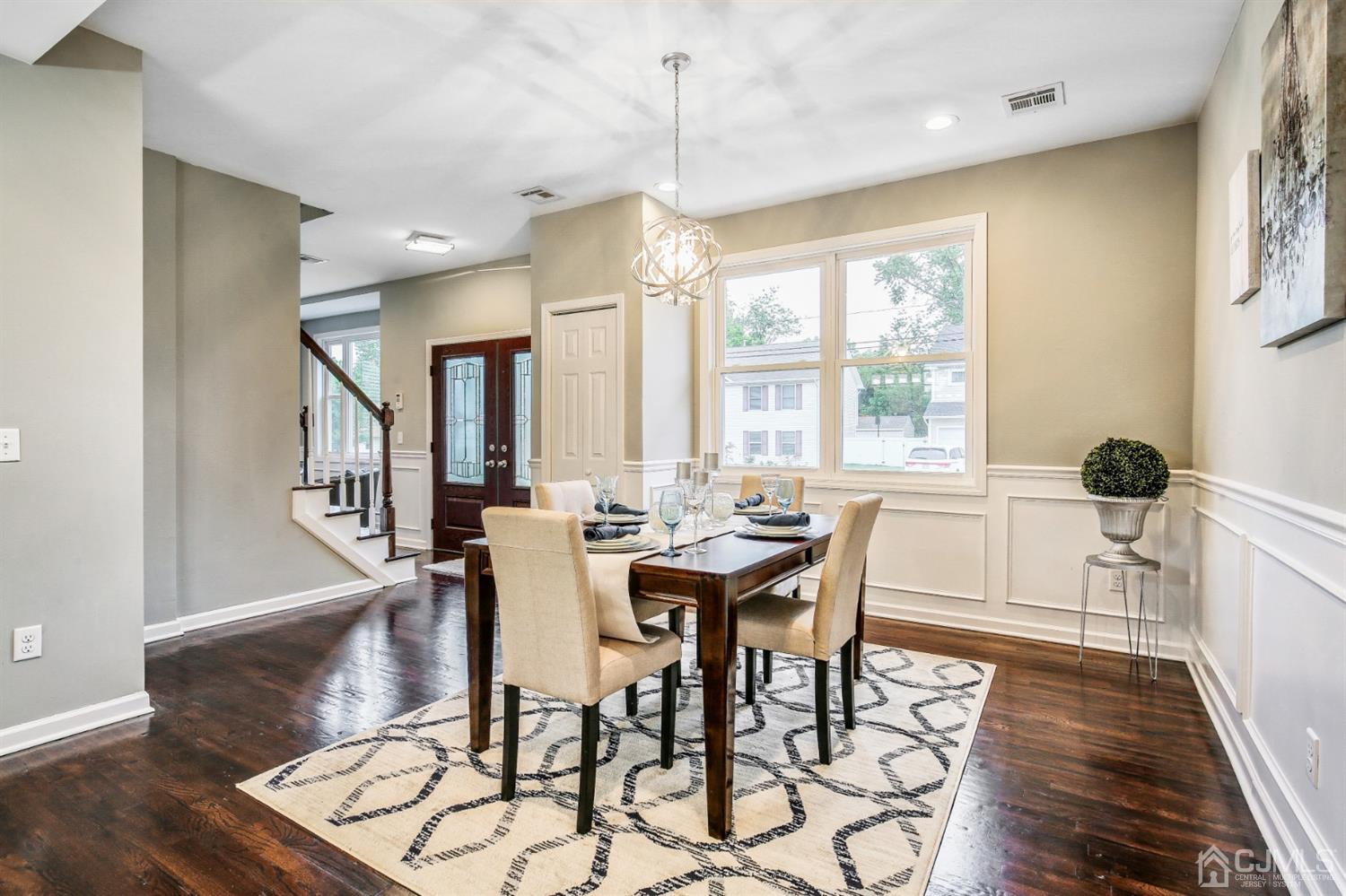 9 Markham Road Edison, NJ 08817 - Photo 13 of 28 a dining room with wooden floor a chandelier a wooden table and chairs
