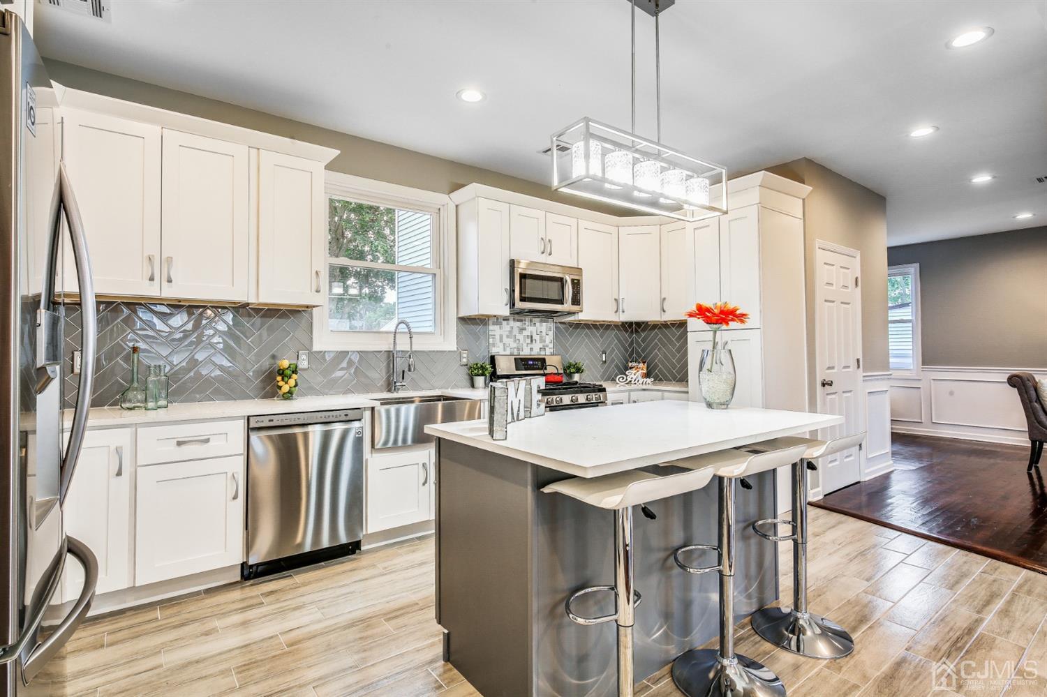 9 Markham Road Edison, NJ 08817 - Photo 9 of 28 a kitchen with stainless steel appliances granite countertop a stove a sink dishwasher a microwave oven with a dining table and chairs