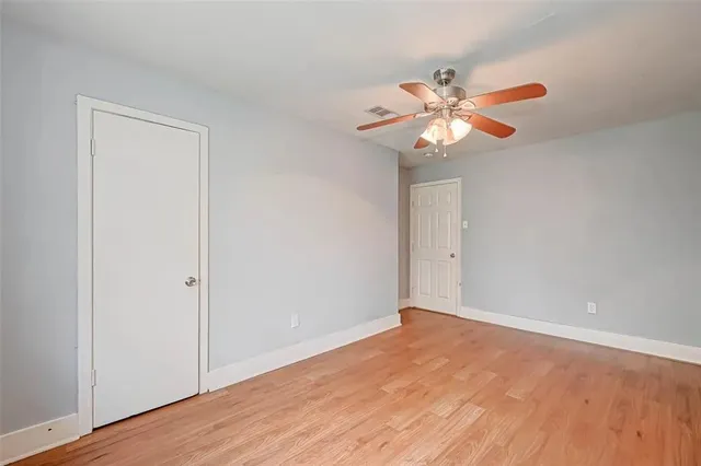 a view of an empty room and chandelier fan