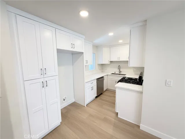 a kitchen with granite countertop white cabinets and white appliances