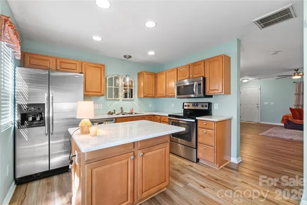 a kitchen with stainless steel appliances granite countertop a sink stove microwave and refrigerator