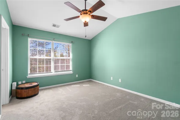 an empty room with a window and a ceiling fan