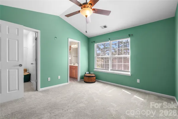 a view of an empty room with a window and a ceiling fan