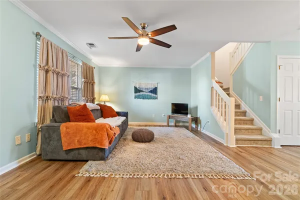 a living room with furniture and a wooden floor