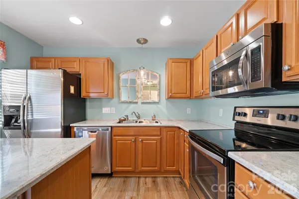 a kitchen with stainless steel appliances granite countertop a sink stove and cabinets