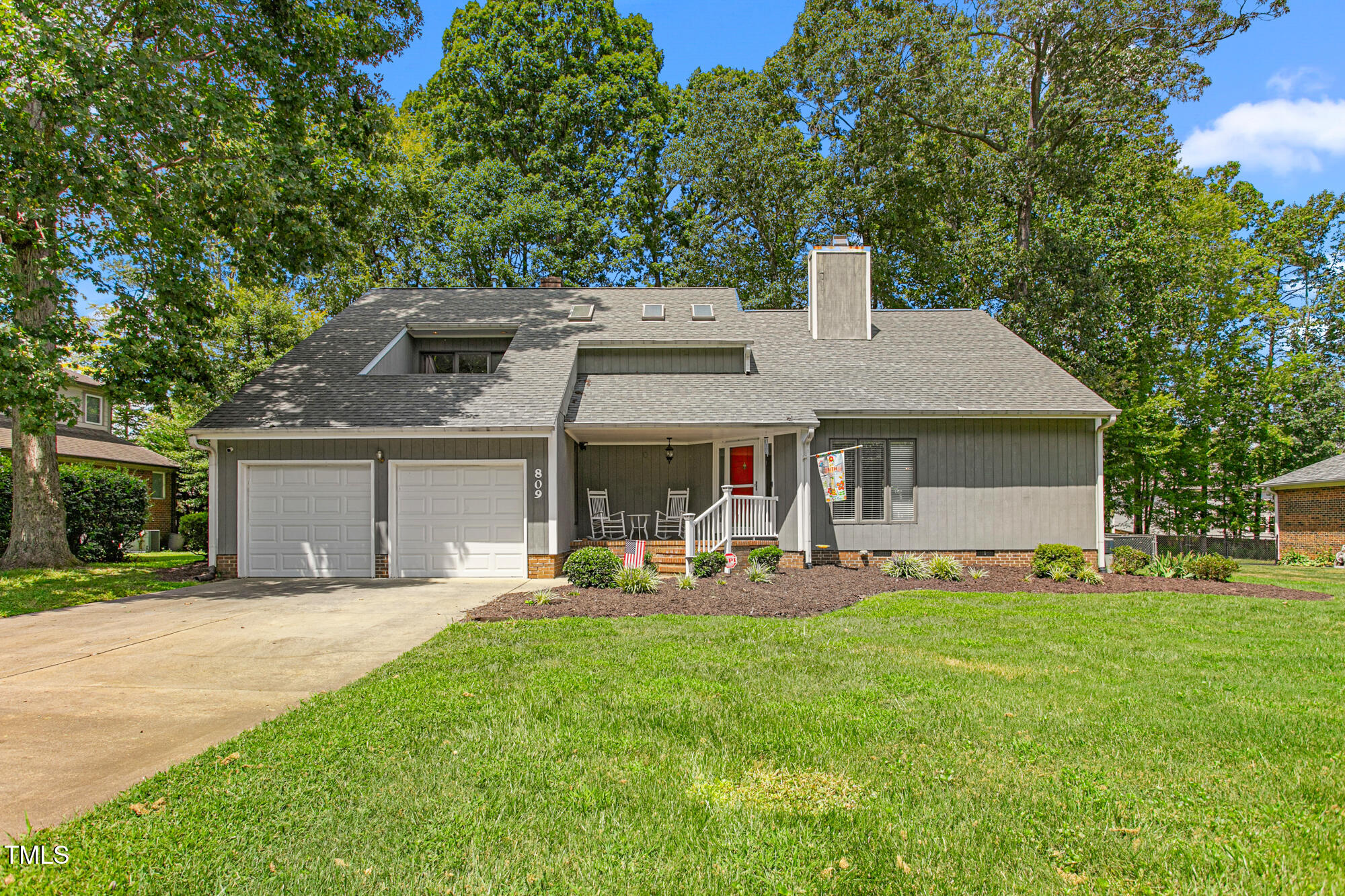 809 Brookview Drive Elon, NC 27244 - Photo 2 of 53 a front view of a house with a garden and trees