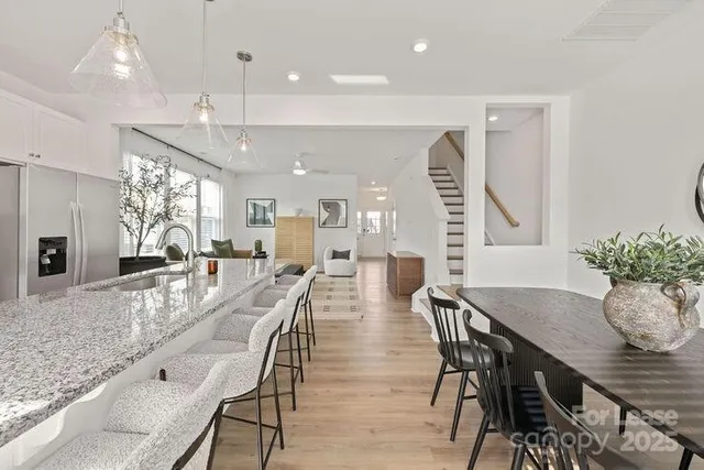 a kitchen with stainless steel appliances granite countertop a table chairs stove a refrigerator and cabinets