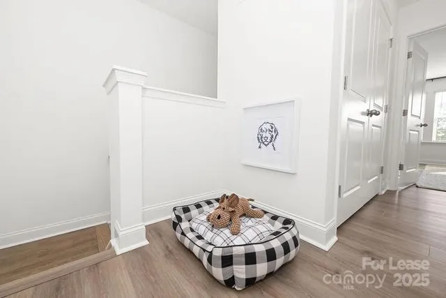 a bedroom with a bed wooden floor and window