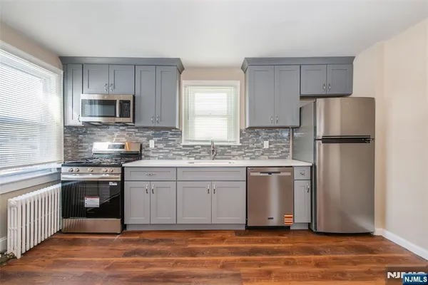 a kitchen with stainless steel appliances granite countertop a refrigerator stove a sink and a microwave