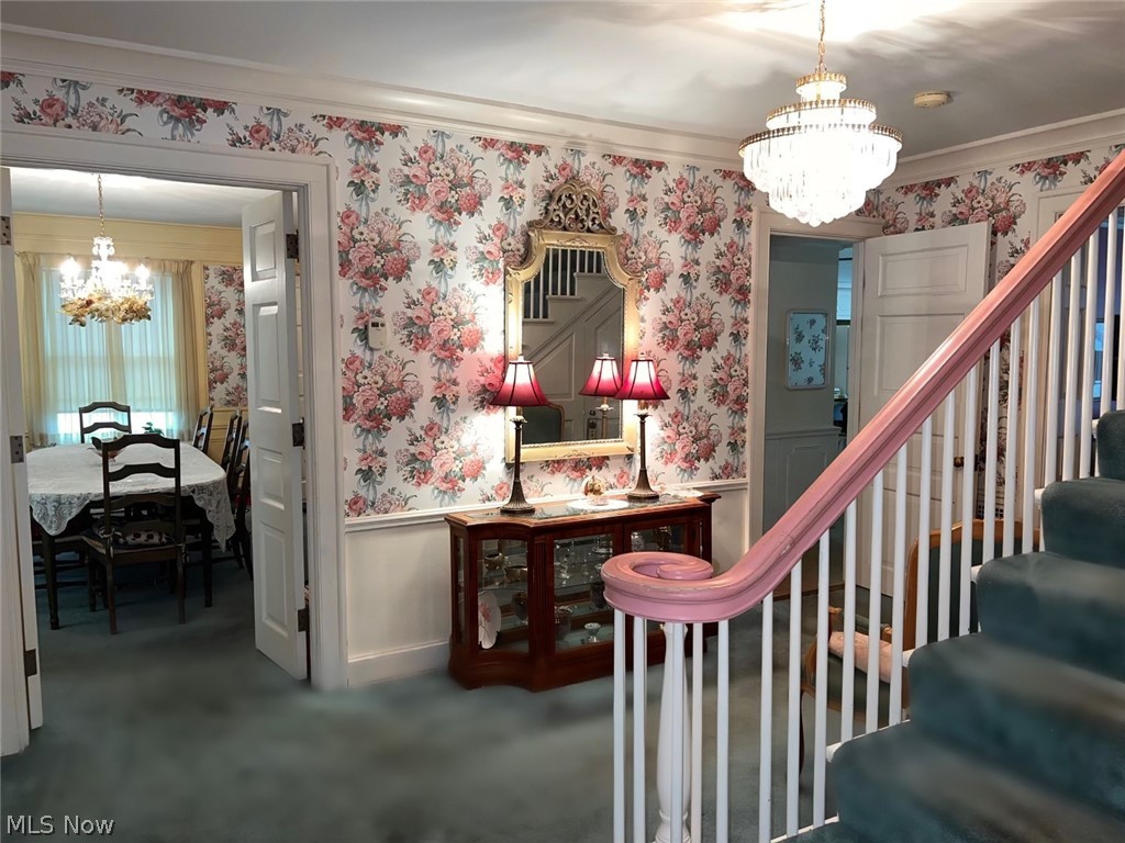 41 Stratford Road Painesville, OH 44077 - Photo 17 of 38 Stairway featuring ornamental molding, carpet floors, and an inviting chandelier