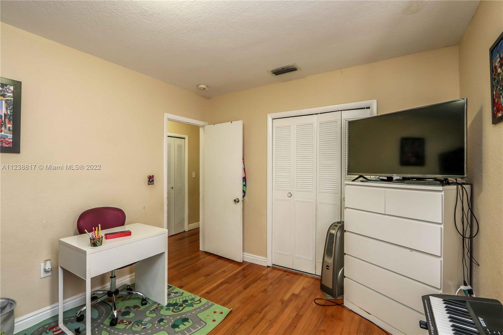 2810 Southwest 26th Street Miami, FL 33133 - Photo 17 of 33 a room with a flat screen tv wooden floor and closet
