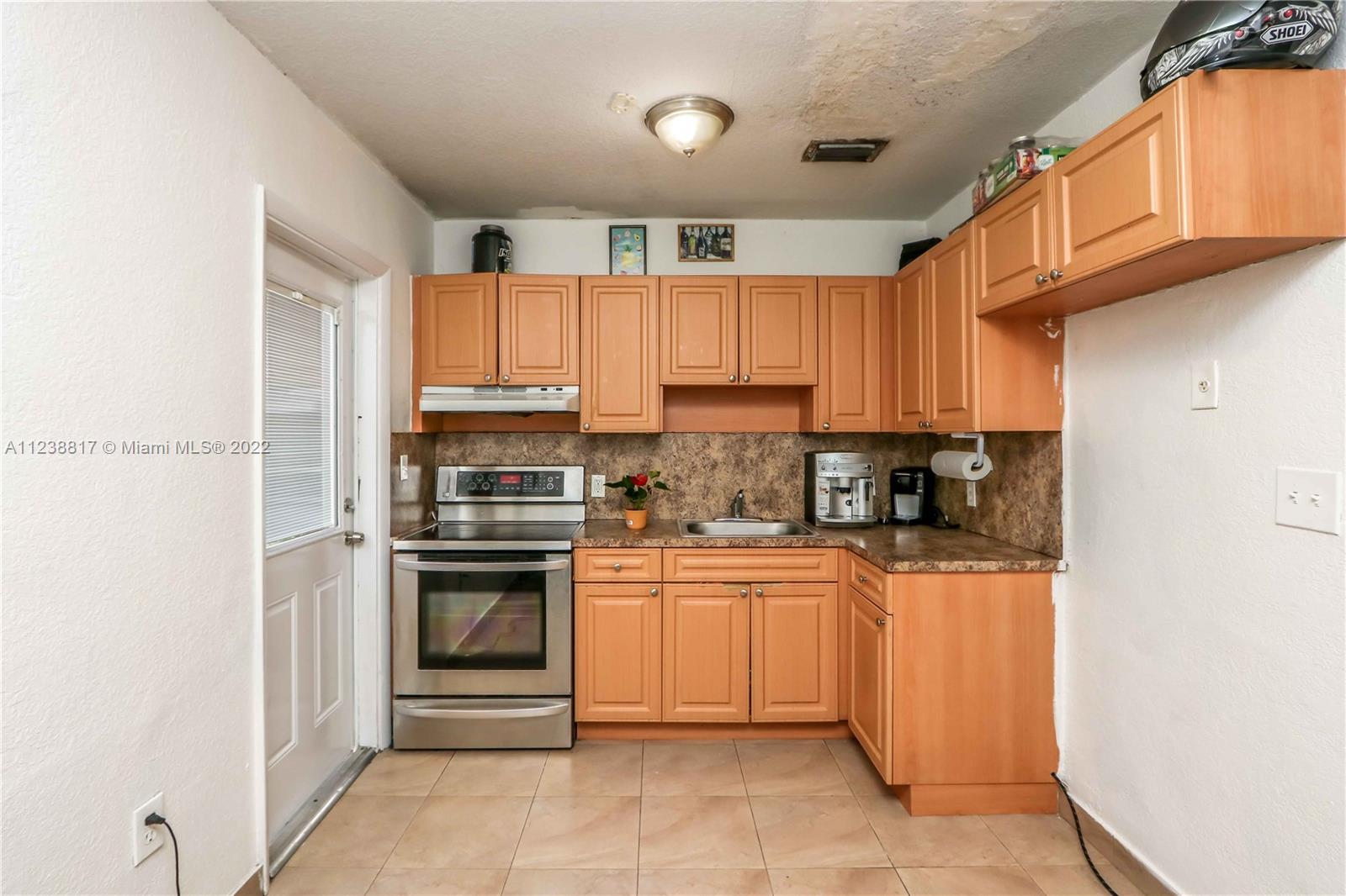 2810 Southwest 26th Street Miami, FL 33133 - Photo 28 of 33 a kitchen with stainless steel appliances granite countertop a refrigerator and a stove top oven