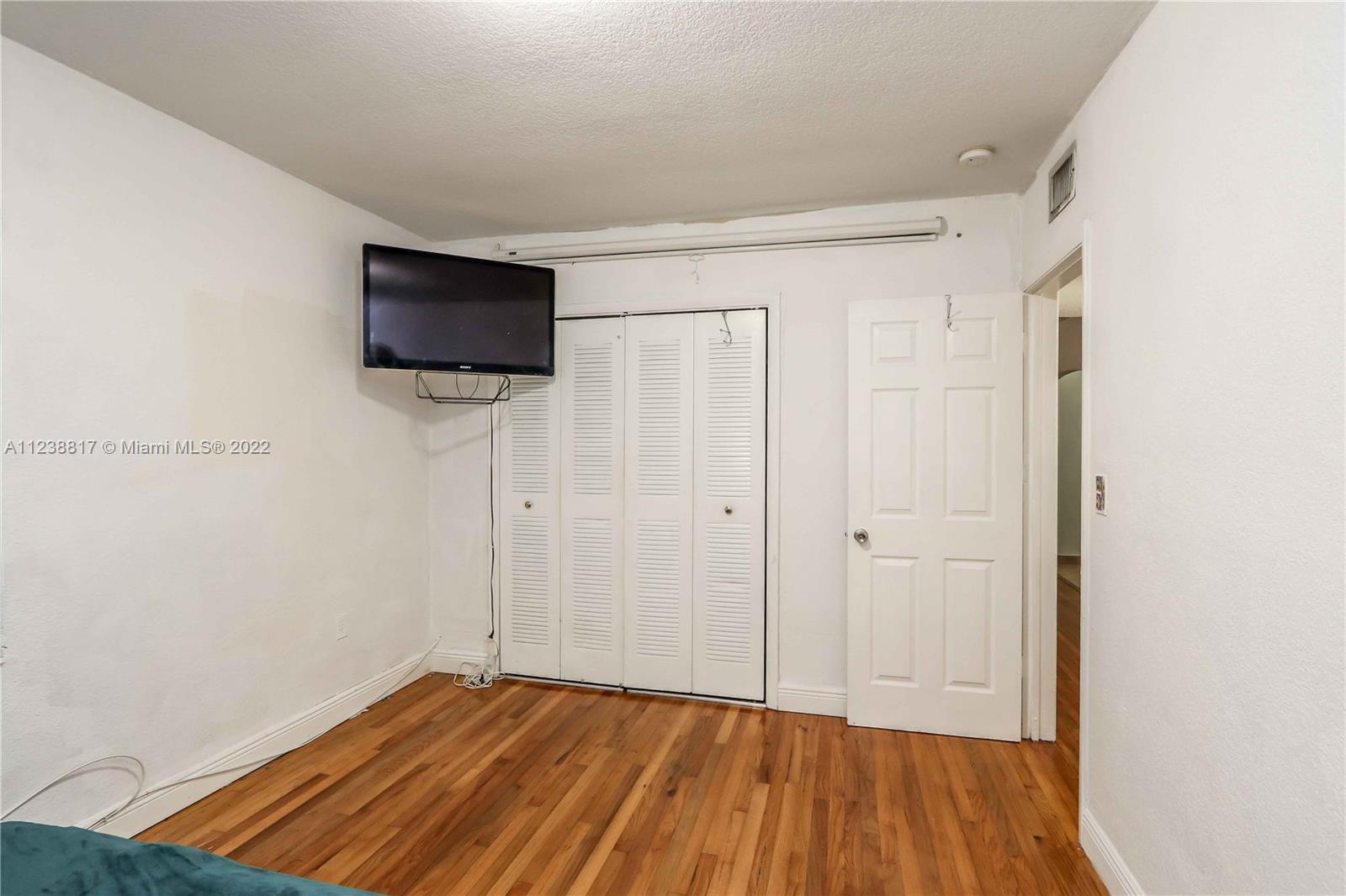 2810 Southwest 26th Street Miami, FL 33133 - Photo 30 of 33 a view of empty room with wooden floor and fan