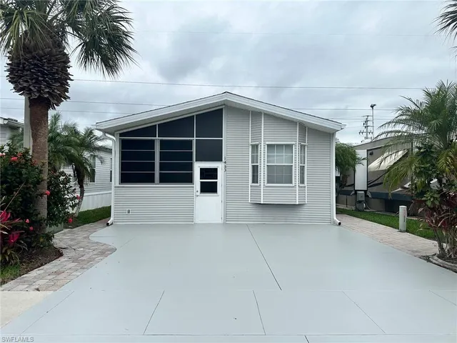front view of a house with a yard and potted plants