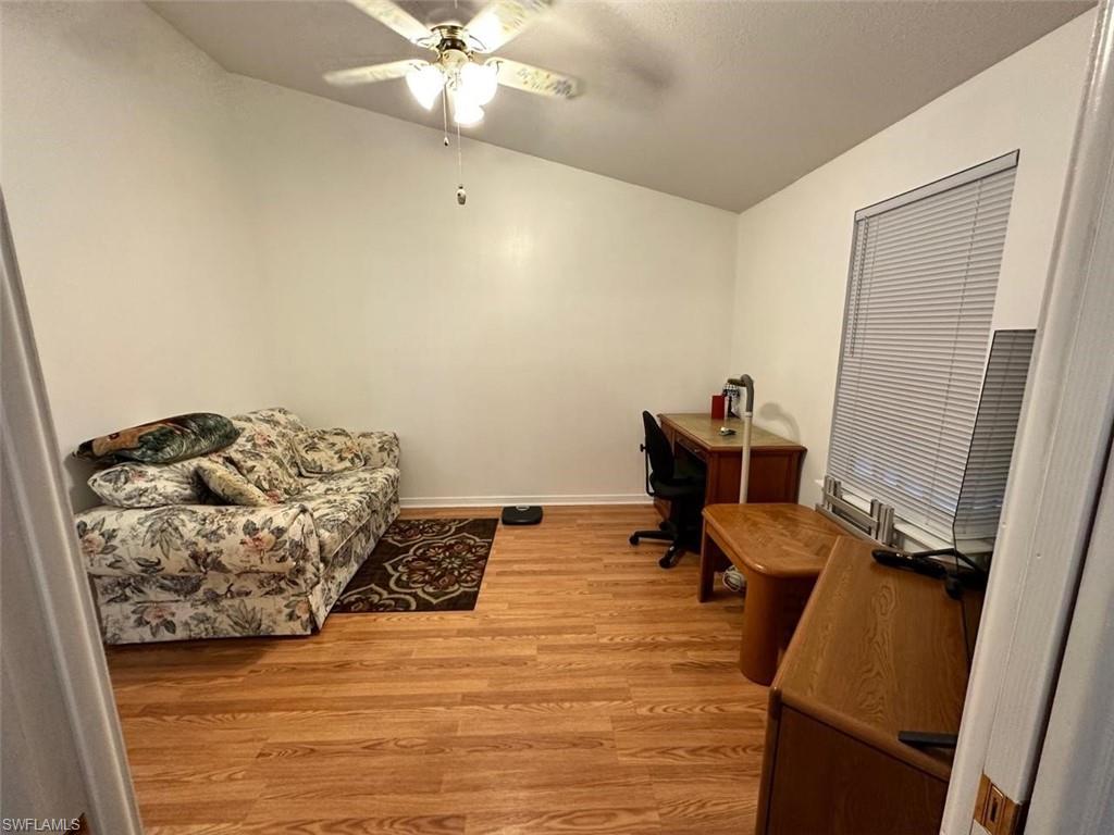 1453 Diamond Lake Circle Naples, FL 34114 - Photo 11 of 18 a bedroom with a bed and wooden floor