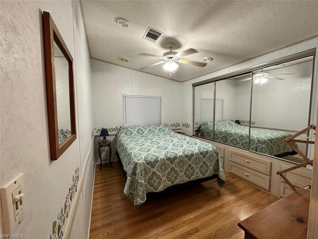 1453 Diamond Lake Circle Naples, FL 34114 - Photo 8 of 18 a bedroom with a large bed and a chandelier