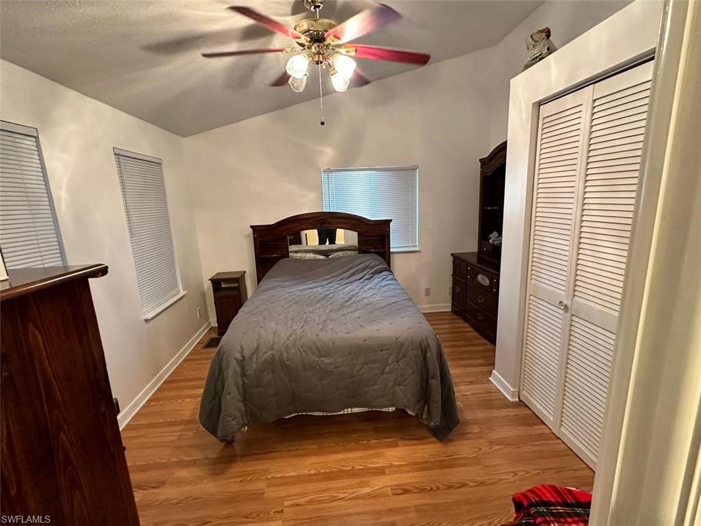 1453 Diamond Lake Circle Naples, FL 34114 - Photo 10 of 18 a bedroom with a bed and wooden floor